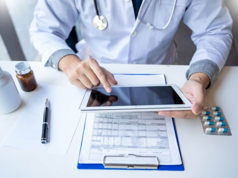 Arzt mit Tablet und Fallakte