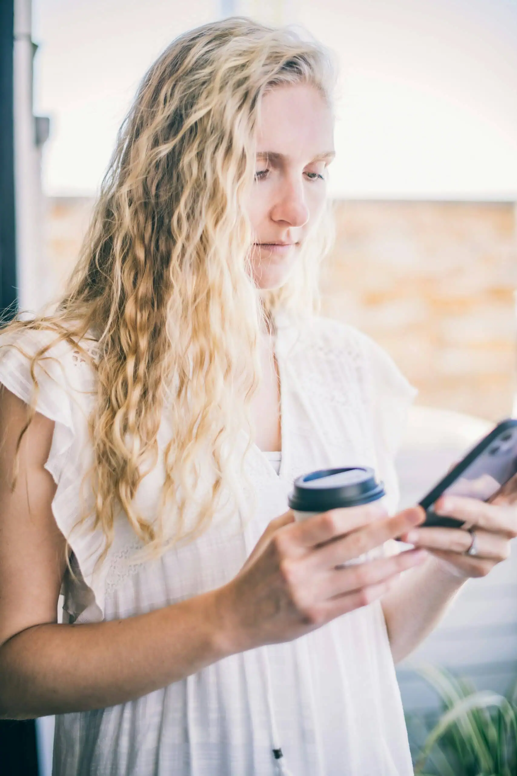 Frau mit Kaffee und Smartphone
